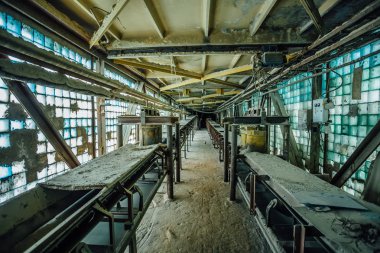 Terk edilmiş fabrika. Gl 'nin eski koridorunda eski tozlu taşıma bandı.