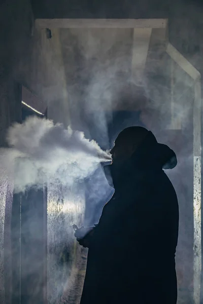 Smoking or vaping man silhouette in dark gloomy corridor — Stock Photo, Image