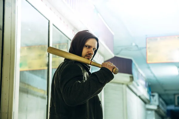 Street hooligan with wooden bat in subway — Stock Photo, Image