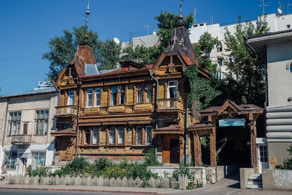 Ancien manoir en bois avec sculptures sur bois à côté de bâtiments modernes . — Photo