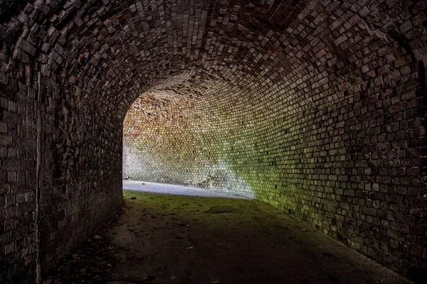 Underjordiska välvda röda tegel tunneln under övergivna tyska fortet — Stockfoto