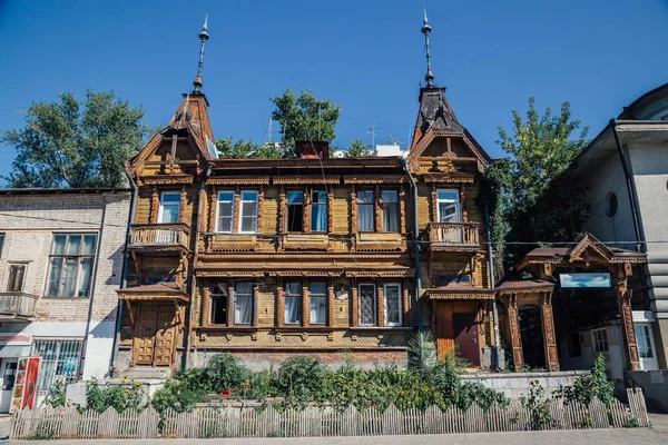 Altes Holzhaus mit Holzschnitzereien neben modernen Gebäuden. — Stockfoto