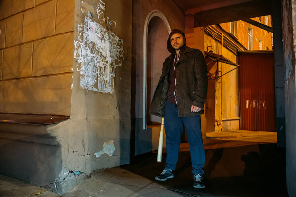 Street hooligan with wooden baseball in night city