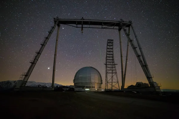 Vista nocturna. Un observatorio astrofísico especial y una grúa agai — Foto de Stock