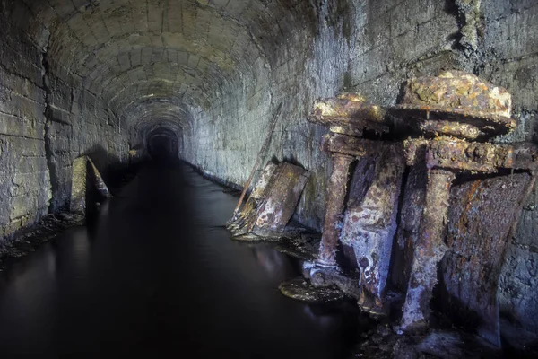 Tunneln i en gammal övergiven gruva med rostiga rester av troll — Stockfoto