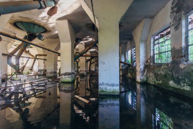 Sular altında kalan harabe un fabrikası fabrikası. Eski paslı borular 