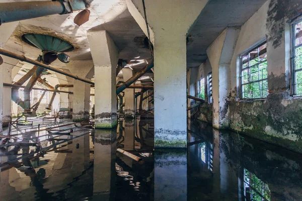 Flooded abandoned ruined flour mill factory. Old rusty pipes in — Stock Photo, Image