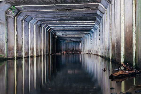 El túnel de alcantarillado inundado se refleja en el agua. Aguas residuales urbanas sucias —  Fotos de Stock