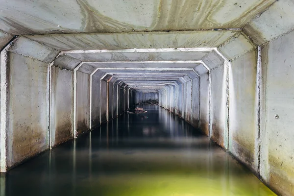 被洪水淹没的下水道隧道在水中反射。肮脏的城市污水 — 图库照片