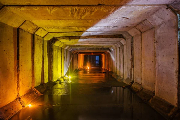 Zaplavený obdélníkový kanalizace tunel se špinavou městskou kanalizace illumin — Stock fotografie