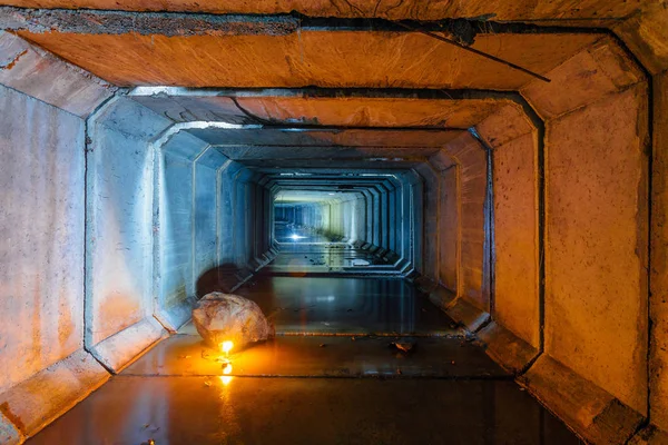 Flooded rectangular sewer tunnel with dirty urban sewage illumin — Stock Photo, Image