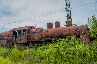 Terk edilmiş tren. Terk edilmiş demiryolu. Eski paslı buharlı lokomotif o