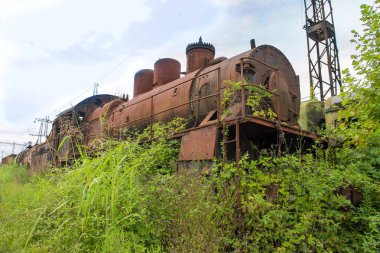 Terk edilmiş tren. Terk edilmiş demiryolu. Eski paslı buharlı lokomotif o