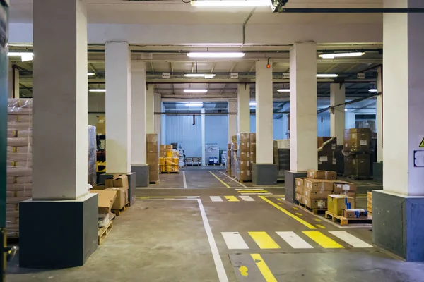 Interior do armazém industrial. Mercadorias em cartonagem e polietileno — Fotografia de Stock