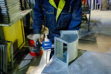 Metal işleme tesisinde çalışan işçi, c için parçaya perçin döşeyerek