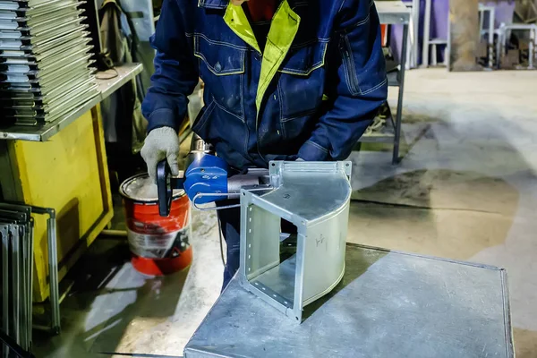 Metal işleme tesisinde çalışan işçi, c için parçaya perçin döşeyerek