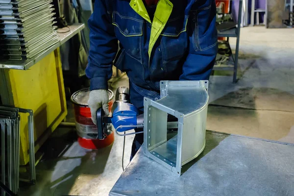 Pracownik w zakładzie obróbki metali instalujący nity w części do c — Zdjęcie stockowe