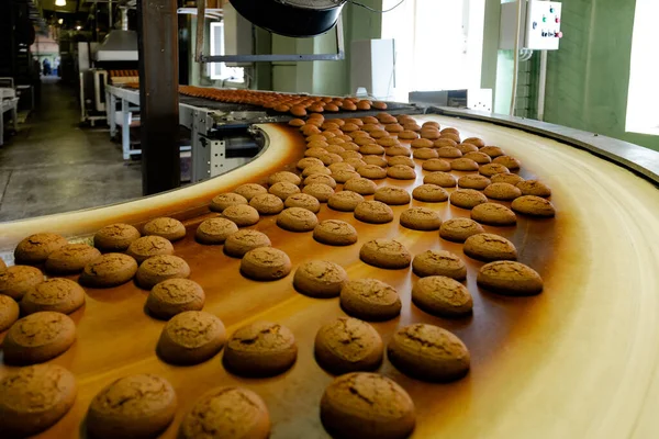 Linha de produção de fábrica de confeitaria. Cookies em movimento em tur — Fotografia de Stock