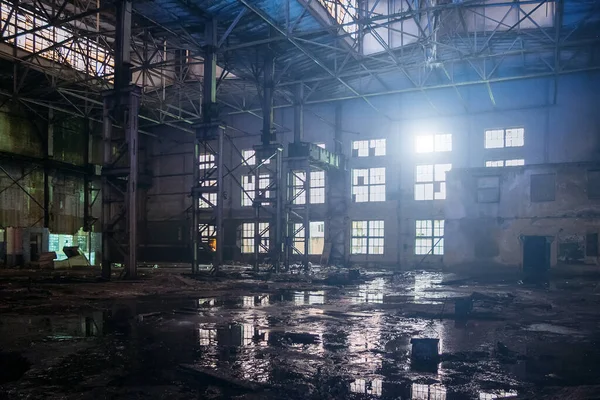 Dunkel schmutzig geflutet schmutzig verlassene Industriehalle mit Wasserspiegelungen in der Nacht — Stockfoto