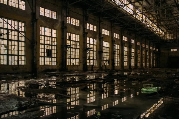 Oscuro sucio inundado sucio abandonado arruinado edificio industrial con reflejos de agua en la noche — Foto de Stock