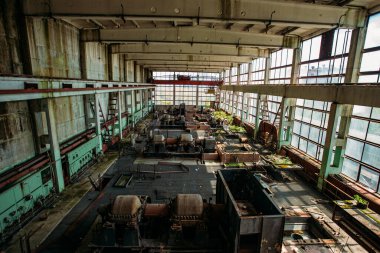 Eski terk edilmiş fabrika, atölyesinde paslı endüstriyel makineler var..