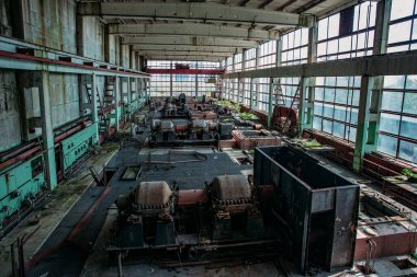 Eski terk edilmiş fabrika, atölyesinde paslı endüstriyel makineler var..
