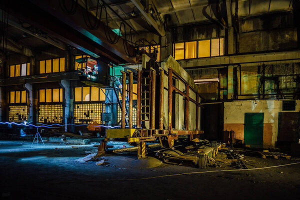 Old broken empty abandoned industrial building interior at night.