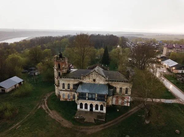 Staré opuštěné zbořené sídlo v gotickém stylu s barevnými okny v Avchurinu, letecký pohled — Stock fotografie