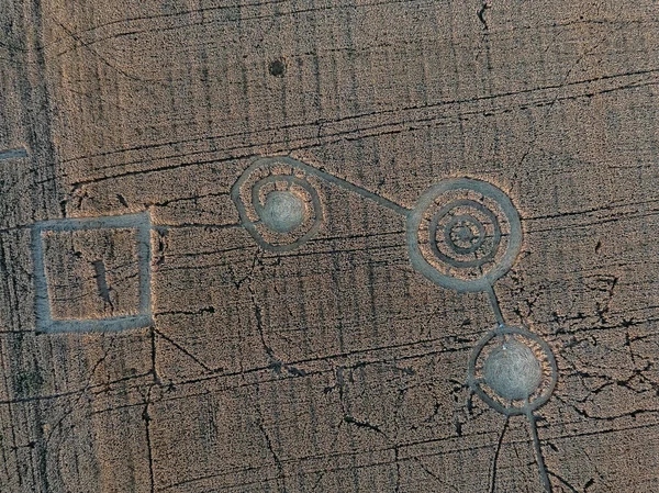 Mysterious crop circle in oat field near the city, aerial view.