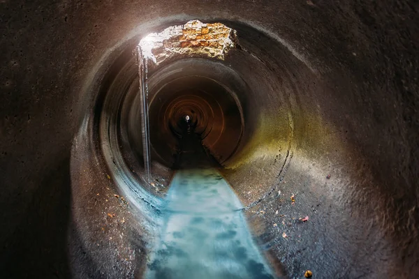Industrial wastewater and urban sewage flowing through round sewer pipe.