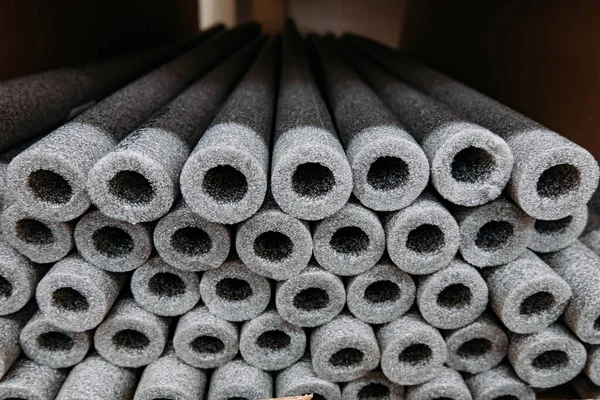 Stacked insulation for pipes of polyethylene foam in warehouse.