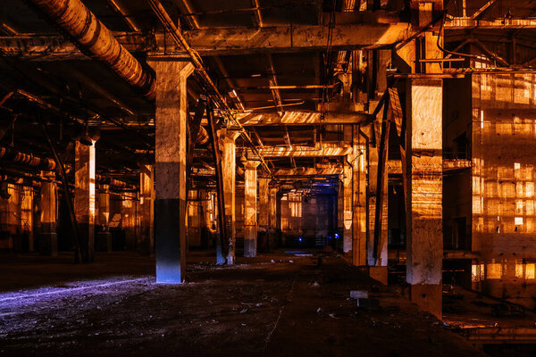 Dark creepy empty abandoned industrial building interior at night.