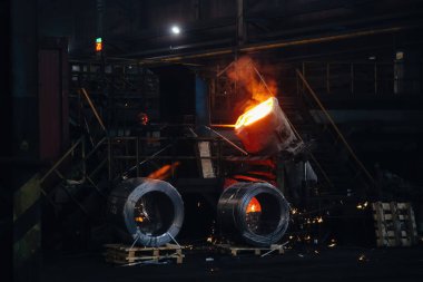 İşçi metalurji fabrikasında metal döküm işlemi yürütüyor.
