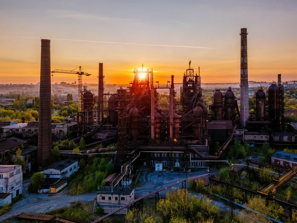 Blast furnace equipment of the metallurgical plant at the sunset, aerial view.