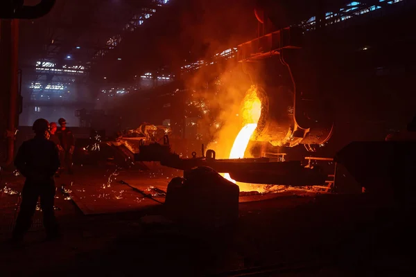 Metal casting process in metallurgical plant. Liquid metal pouring into molds.
