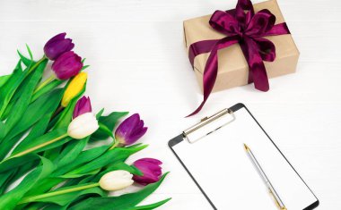 Beyaz arkaplanda çiçekler ve bir hediye