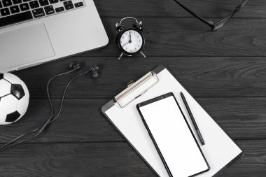 telefon, çalar saat, gözlük ve dizüstü bilgisayar siyah bir arkaplanda