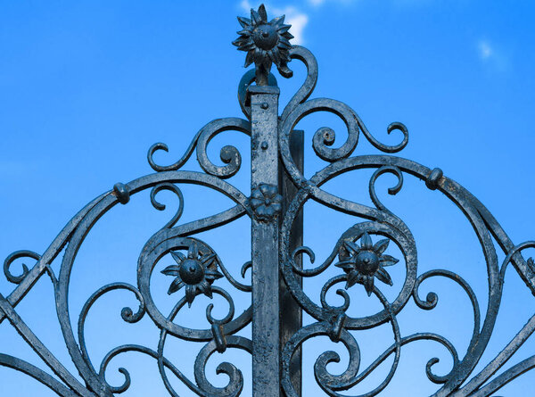 кованые железные ворота против неба
