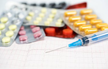 Bir kardiyogram hapları ve kardiyoloji yığını ile yalan bir tıbbi şırınga
