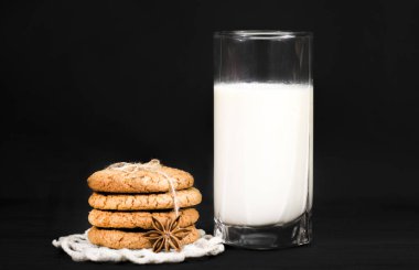 Zencefilli kurabiye ve süt siyah bir zemin üzerine