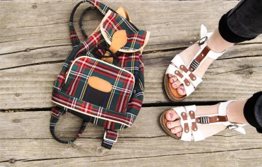 Kadın sandalet ve ahşap arka plan üzerinde sırt çantası