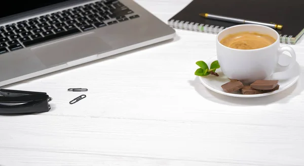 hot coffee with chocolate and a laptop on a wooden place