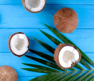 Ahşap masa üzerinde palmiye yaprakları olan hindistan cevizleri