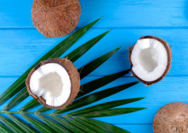 Ahşap masa üzerinde palmiye yaprakları olan hindistan cevizleri