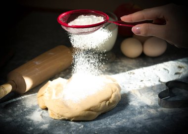 Mangır yapmak için un taşıyan erkek elleri, üst görünüm. siyah arkaplan. 
