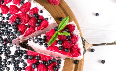 Ahududulu Cheesecake Beyaz ahşap bir arka planla Yakın plan