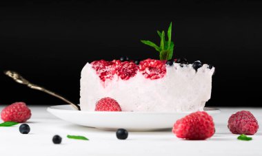 Koyu arkaplanda böğürtlenli yaz süzme peynirli kek bulunur.