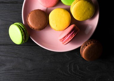 Siyah ahşap bir arka planda sakaroonlar