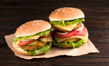Ahşap arka planda iki hamburger.