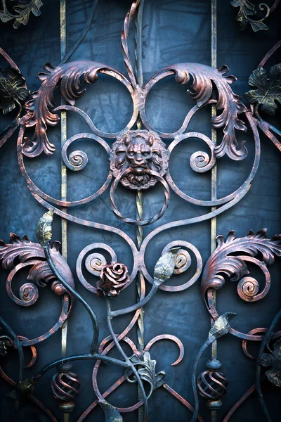 Aslan başı şeklinde saplı siyah dövmeli demir kapı.